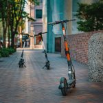 Patinetes elétricos estacionados em uma calçada urbana, representando uma opção de mobilidade nas cidades.