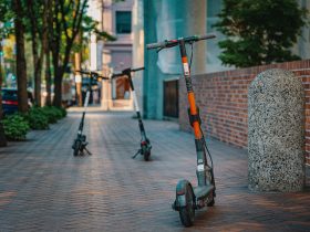 Patinetes elétricos estacionados em uma calçada urbana, representando uma opção de mobilidade nas cidades.