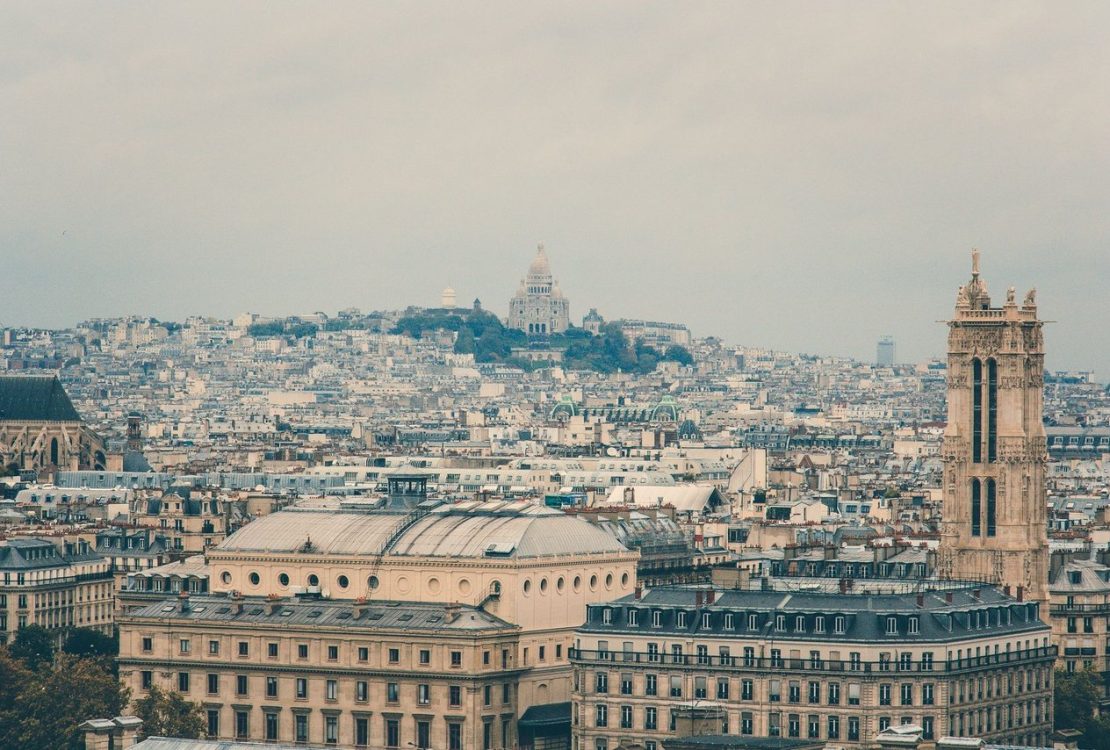 Vista panorâmica de Paris com a Basílica de Sacré-Cœur entre os edifícios históricos de Montmartre.