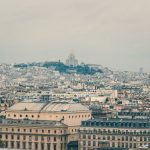 Vista panorâmica de Paris com a Basílica de Sacré-Cœur entre os edifícios históricos de Montmartre.