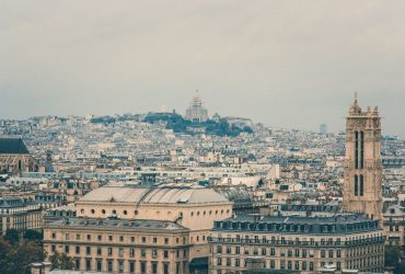 Vista panorâmica de Paris com a Basílica de Sacré-Cœur entre os edifícios históricos de Montmartre.