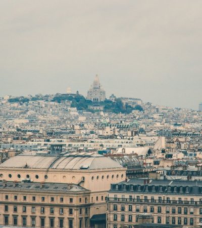 Vista panorâmica de Paris com a Basílica de Sacré-Cœur entre os edifícios históricos de Montmartre.