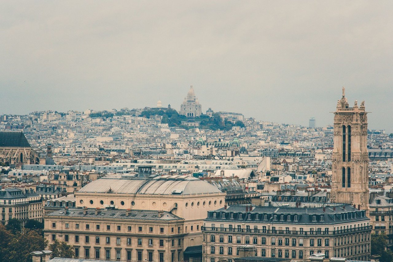 Vista panorâmica de Paris com a Basílica de Sacré-Cœur entre os edifícios históricos de Montmartre.