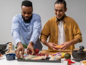 Duas pessoas preparam rolinhos primavera veganos em uma cozinha.